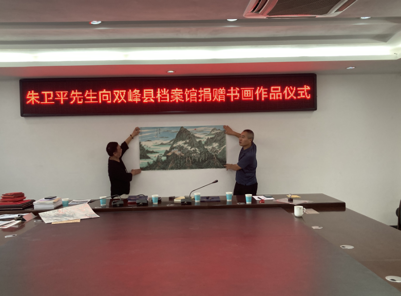 朱卫平和周建良向县档案馆捐赠书画、视频作品